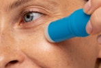 a woman using an under-eye stick