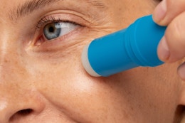 a woman using an under-eye stick
