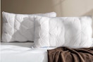 QUTOOL Luxury Hotel Goose Feather Pillow on a bed.