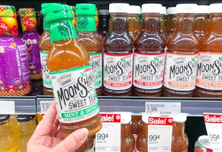 hand holding Moonshine Sweet Tea in front of refrigerated items with the sale price tag showing