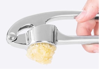 silver garlic press with garlic