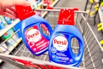person putting persil detergent in a cart