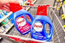 person putting persil detergent in a cart