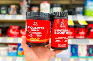 hand holding two containers of supplements in front of store shelves