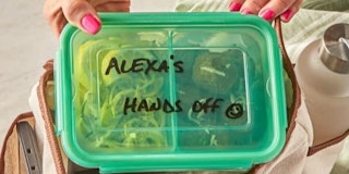 A hand holding a meal prep container