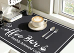 a latte in a cup on a mat next to an espresso machine