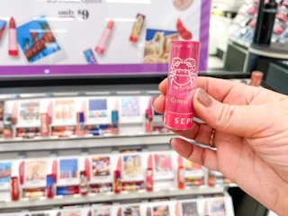 sephora lip balm and stick display in store with lipstick being held in front
