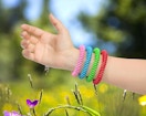 a person wearing colorful mosquito bracelets
