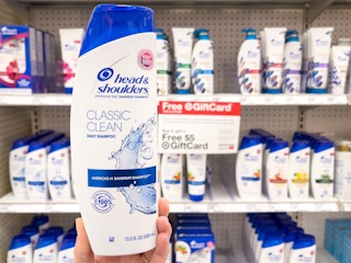 hand holding up shampoo bottle at target in front of shelf