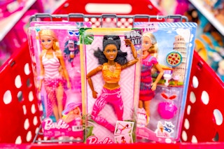 3 barbie doll toys sitting in a target cart