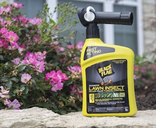 black and yellow pest control bottle outside in a yard