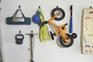 storage hooks holding garage items on wall