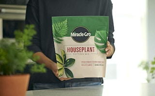 a person holding a bag of soil