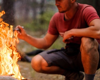 a man at a fire outside