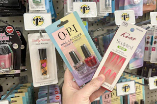 hand holding opi and kiss nail products next to sally hansen nail polish