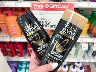 hand holding l'oreal paris elvive shampoo and conditioner at target