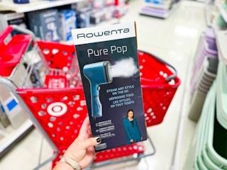 hand holding rowenta garment steamer in front of target cart