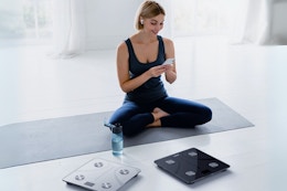 woman sitting on floor near scale