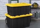 black totes with yellow lids on a dolly