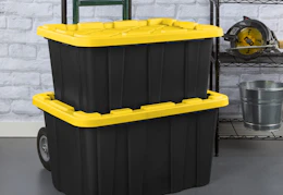 black totes with yellow lids on a dolly