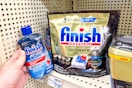 hand holding finish jet dry next to shelf with dishwasher tabs