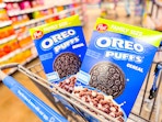 two boxes of Oreo Puffs cereal in a Walmart cart
