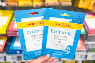 hand holding two burt's bees face sheet masks
