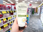 hand holding aveeno facial cleanser