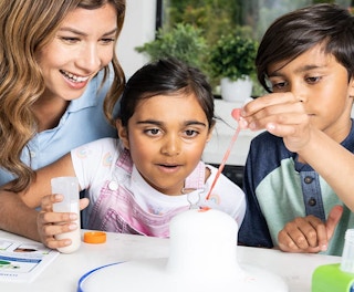 kids and a parent playing with a science kit