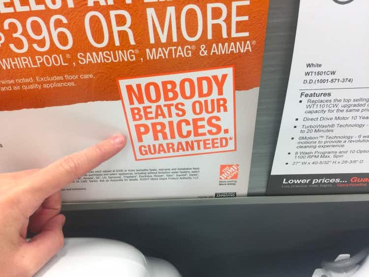 Finger pointing at a Home Depot sign that says, "Nobody beats our prices. Guaranteed."