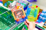 hand holding micro games nerf and kerplunk above dollar tree shopping cart