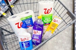 toilet paper, paper towels, trash bags, and cleaning supplies in a cart