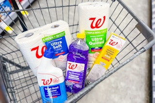 toilet paper, paper towels, trash bags, and cleaning supplies in a cart