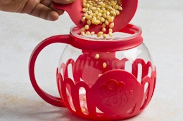 kernels being poured into a popcorn popper
