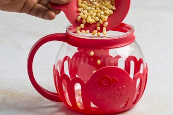 kernels being poured into a popcorn popper
