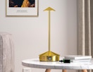 a gold cordless lamp on a table 