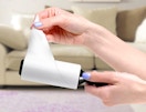 a hand pulling paper off of a lint roller