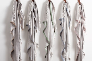 a line of cotton cashmere throws hanging on a wall