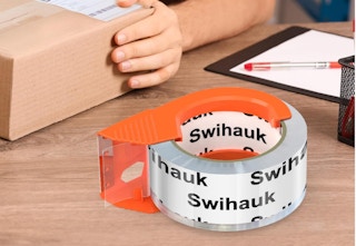 a roll of tape on a dispenser next to a box