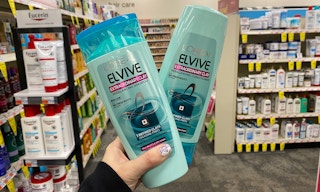 hand holding two bottles of Loreal Elvive shampoo and conditioner