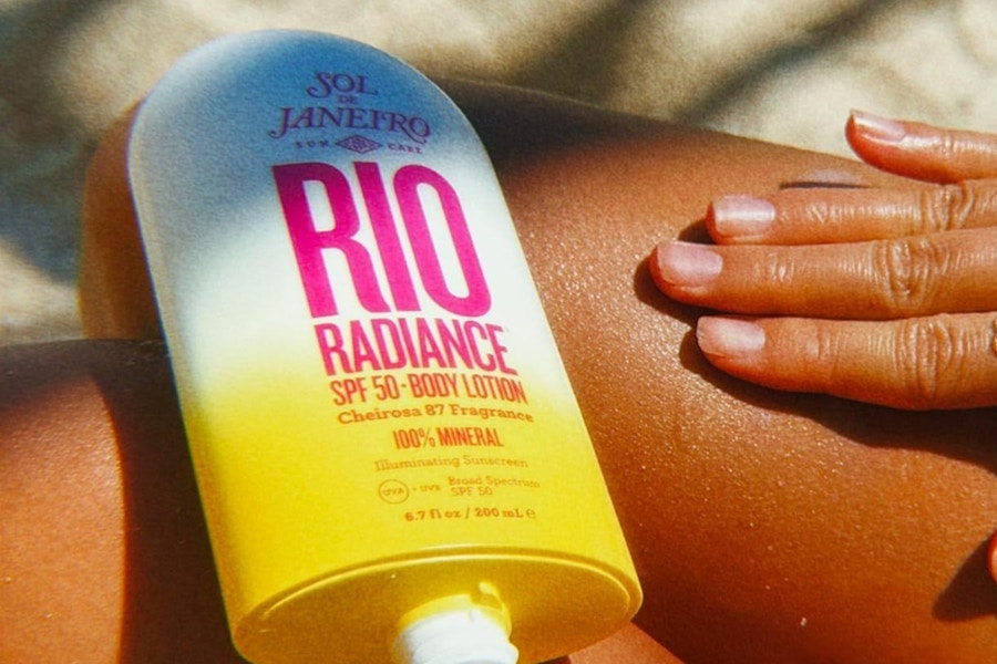 a woman using sol de janeiro spf 50 lotion