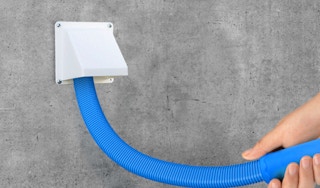 a hand holding a hose while cleaning a dryer vent