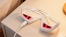 a under-eye red light device charging on a nightstand