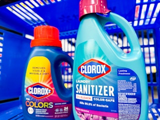 dark blue bottle of Clorox2 Colors stain remover bottle and Clorox Laundry Sanitizer in a Walmart basket