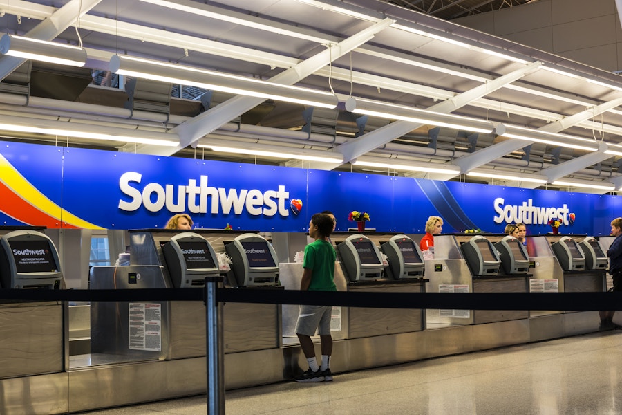 Southwest desk in an airport with passengers waiting to check in.