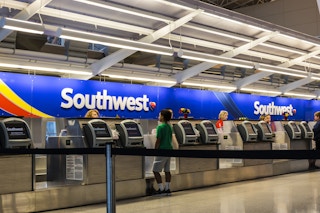 Southwest desk in an airport with passengers waiting to check in.