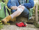 a person using a first aid kit on their knee outside