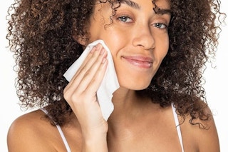 Woman using makeup removing wipe. B07GKVBQDG
