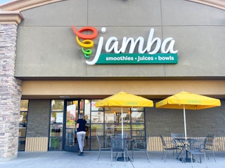 a woman walking into a jamba juice store 