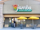 a woman walking into a jamba juice store